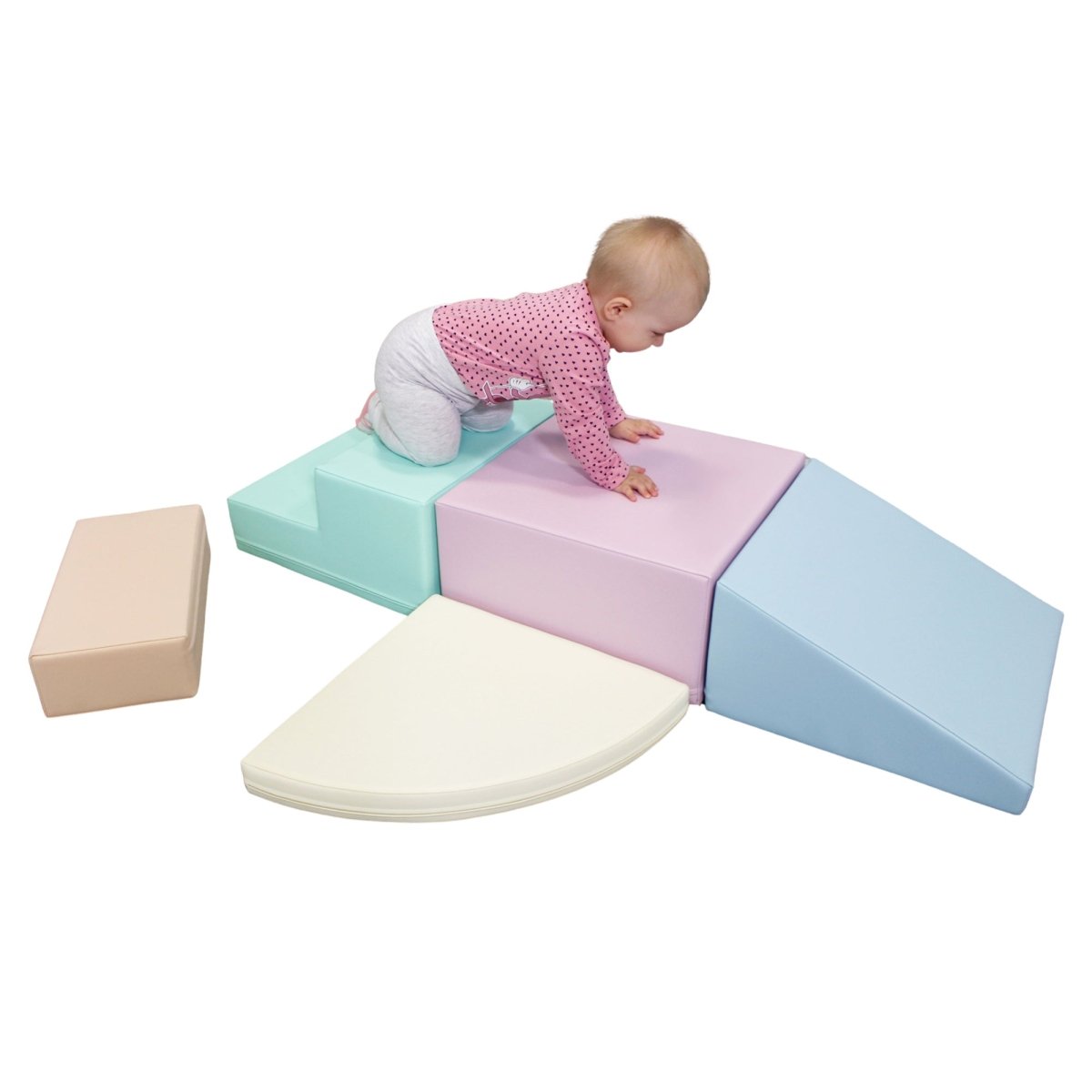 Baby crawling on a pastel-colored soft play set arranged from various shapes: rectangles, wedges, and a semicircle