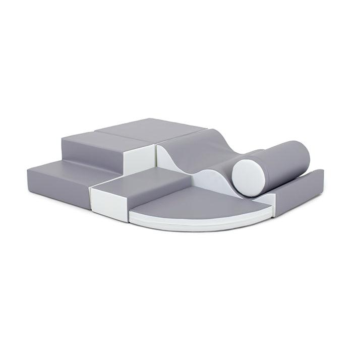 Grey soft play set made from various shapes like a square, cylinder, a wedge, and steps