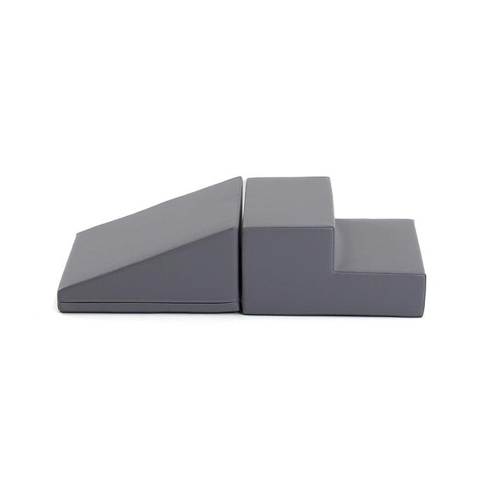 A Soft Play Step and Slide Set - Mini Fun Slider featuring a pair of grey plastic blocks designed for smaller spaces.