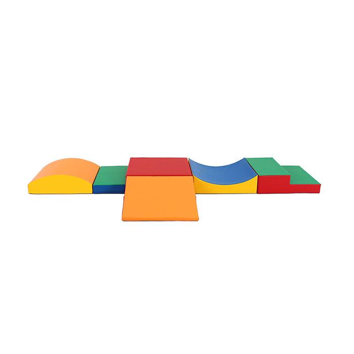 Various, multicolored soft play shapes like wedges, steps, arcs, and squares arranged like an obstacle course