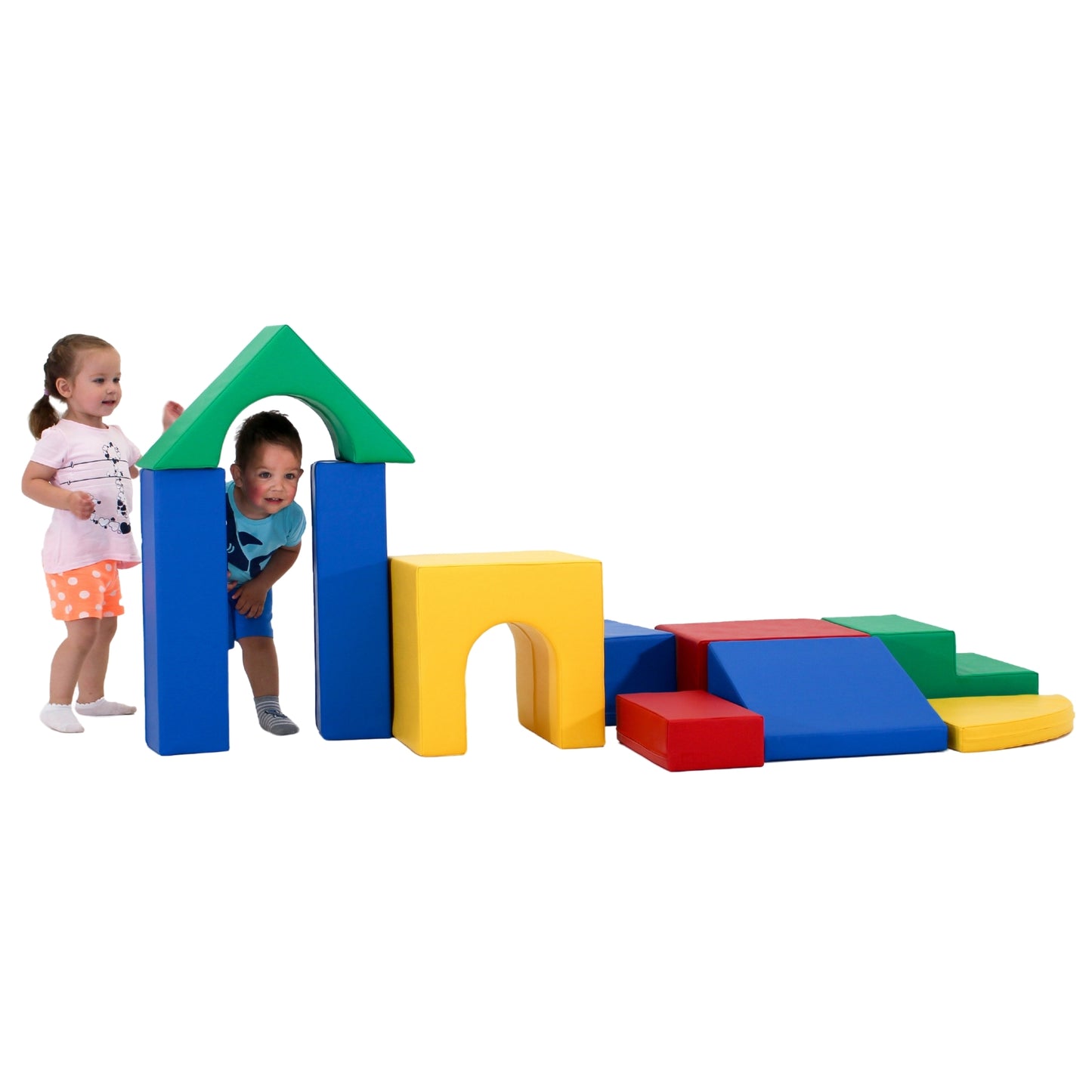 Toddlers constructing a colorful soft play fortress. Vibrant geometric shapes in various sizes form walls, towers, and arches