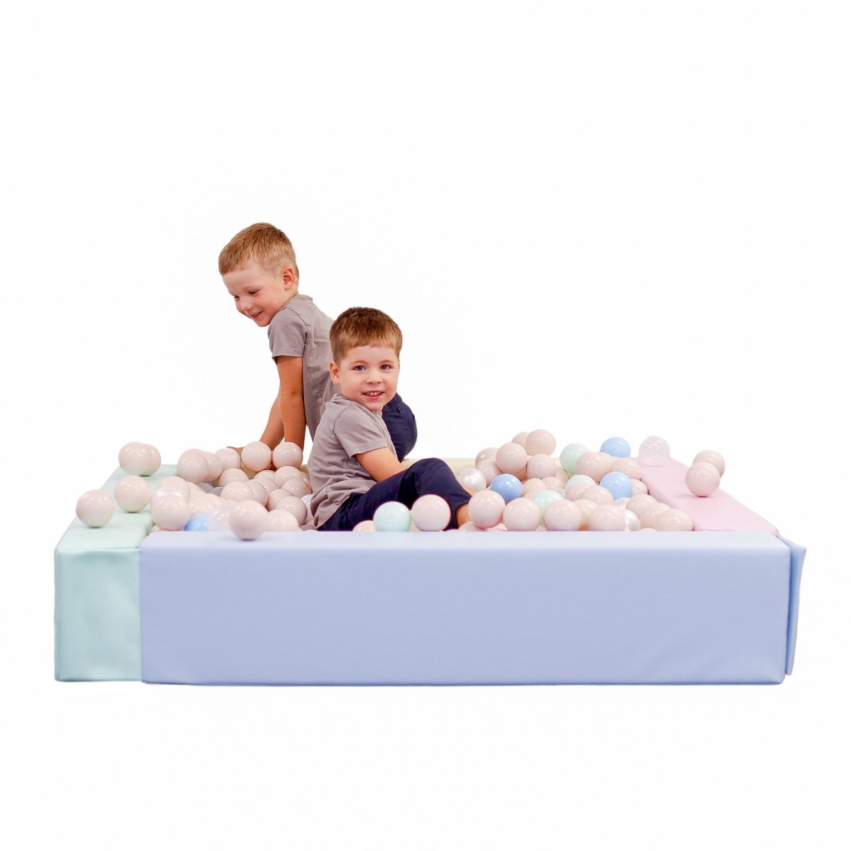 Square foam ball pit with pastel-colored walls filled with colorful balls, featuring toddlers playing inside