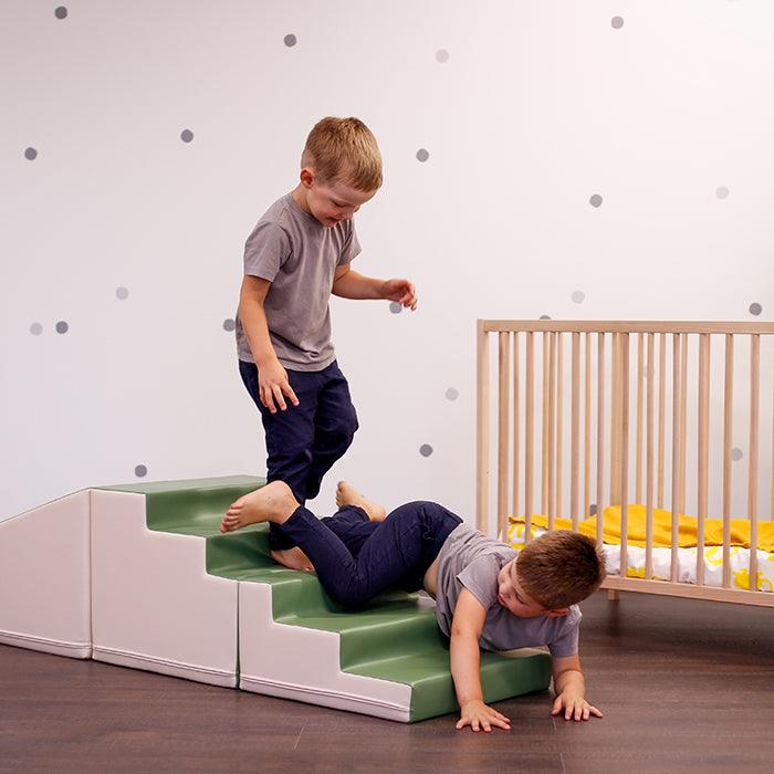 Two boys engaging in imaginative play on a 4 Piece Soft Play Step and Slide Set - Transformer by IGLU Soft Play, promoting gross motor skill development.