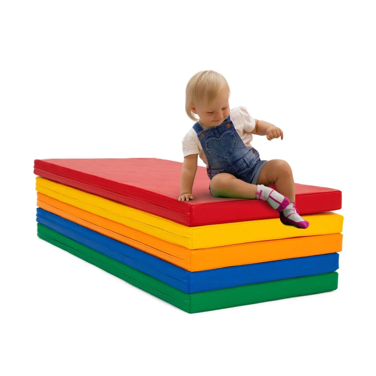 Toddler slides down five colorful soft play mats, stacked on top of each other