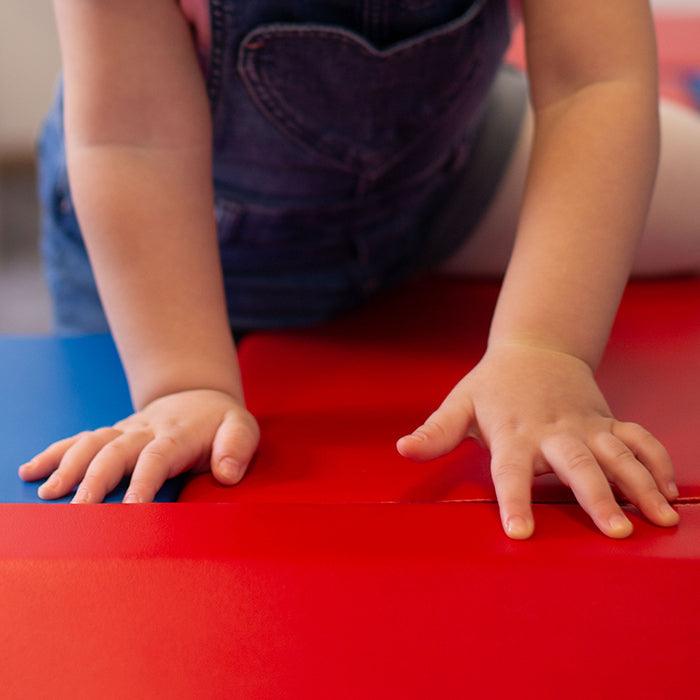 A little girl enjoying the Soft Play Step and Slide Set - Mega Fun Slider on an IGLU Soft Play mat.