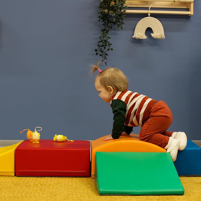 A child is playing with an IGLU Soft Play - Little Crawler toy playset in a room.
