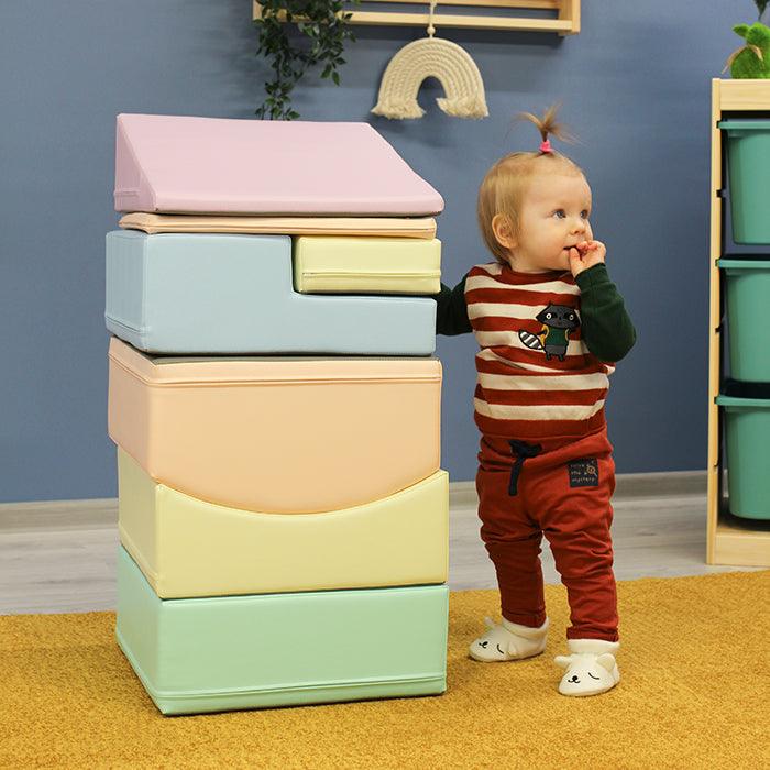 A Soft Play Set - Little Crawler is next to a stack of colorful blocks.
