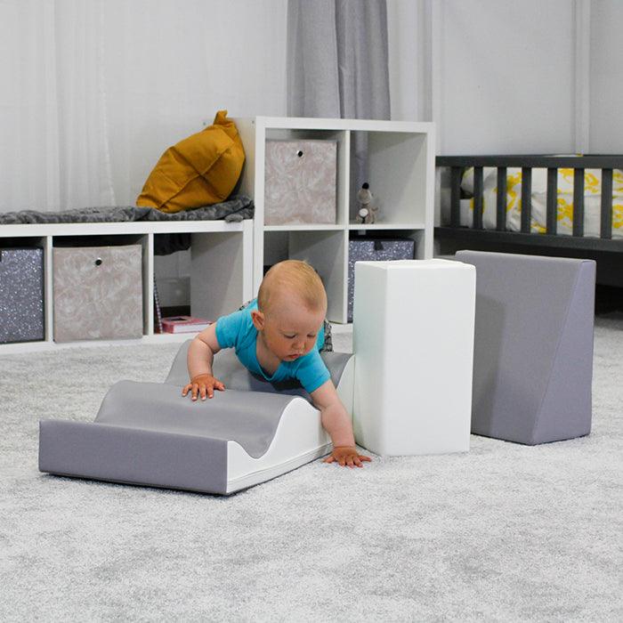 A baby is balancing while playing with the IGLU Soft Play - Wave Walk toy in a room.