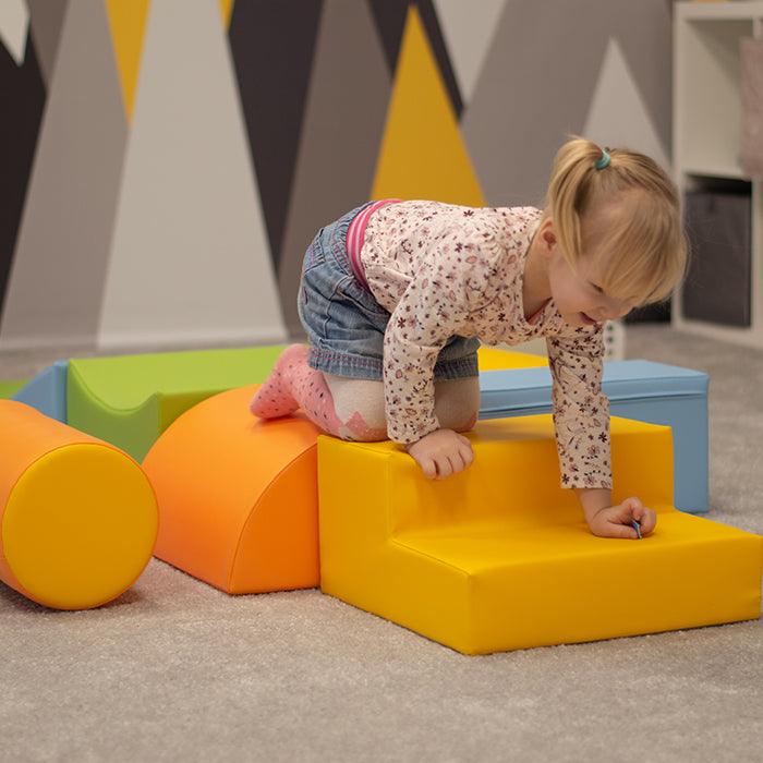 Using the Soft Play Activity Set - Adventurer from IGLU Soft Play, a little girl embarks on imaginative journeys while engaging in physical activity with colorful blocks.