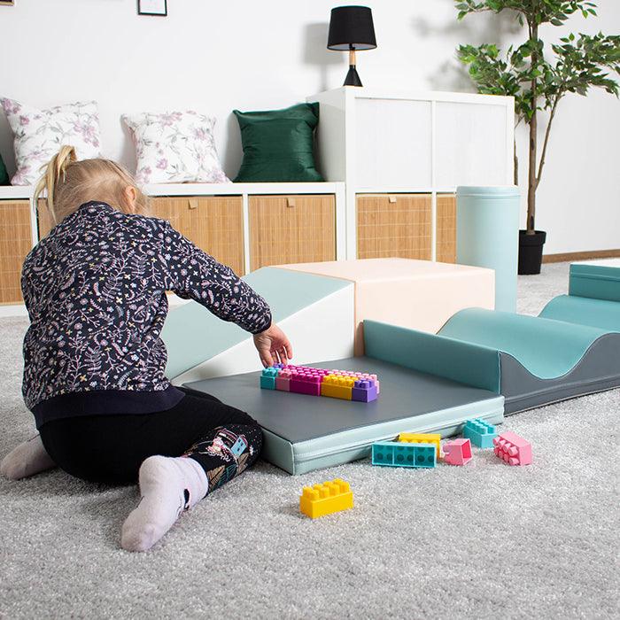 Girl playing with legos on her IGLU foam soft blocks set