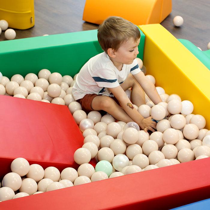 A boy playing inside a foam ball pit