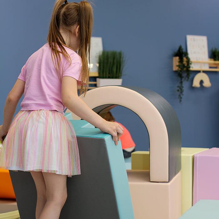 A girl playing with a soft play set
