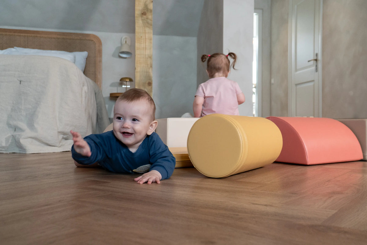 Baby playing on the floor with soft play shapes