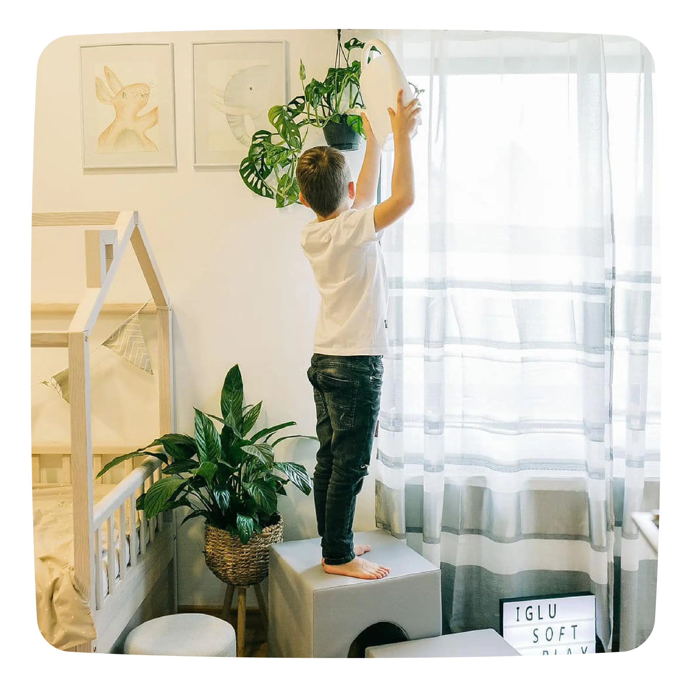 A boy watering plants standing on an IGLU block